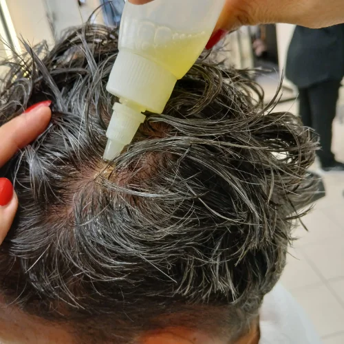 Applicazione di olio essenziale sul cuoio capelluto di un cliente